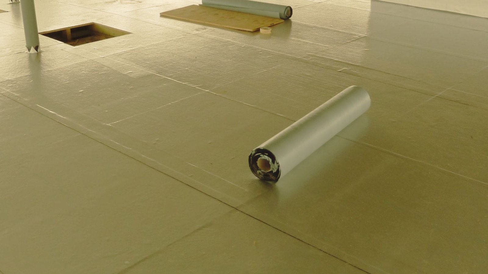 Installing insulation and vapor barrier on a flat roof.