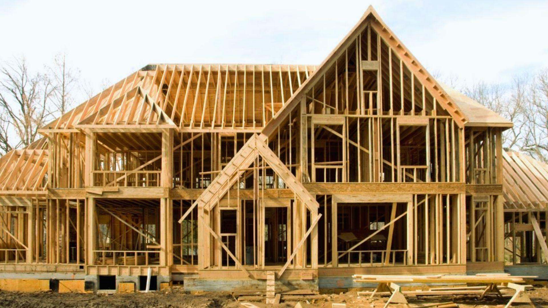Large luxury house wood frame construction with exposed lumber trusses on building site