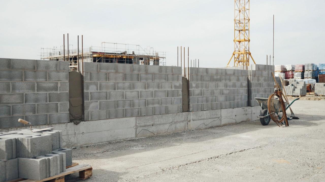 Properly aligned CMU wall construction with reinforced blocks, even mortar joints, grout-filled cores, and a solid footing.