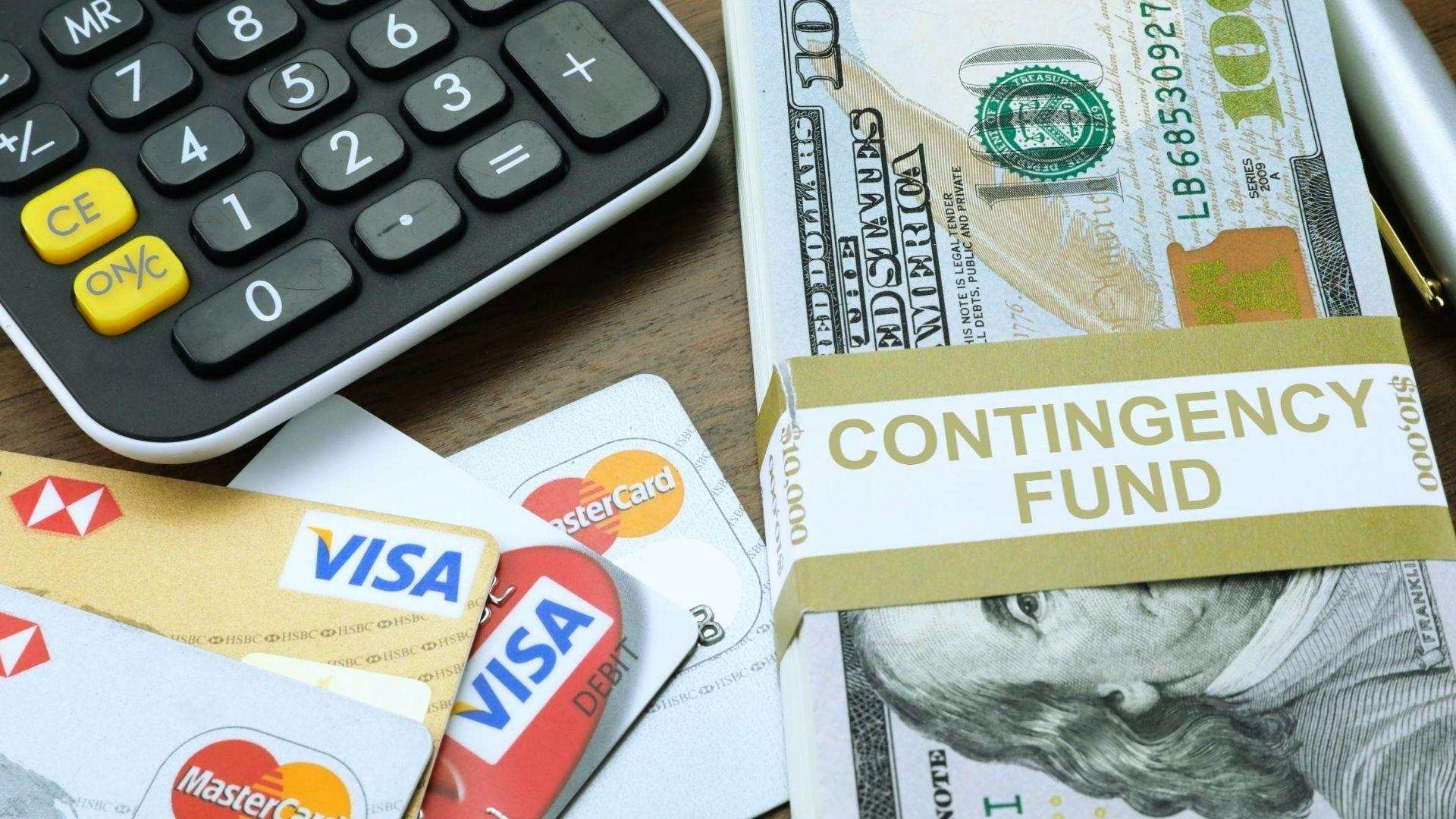 Contingency fund cash bundle with calculator and credit cards for financial planning