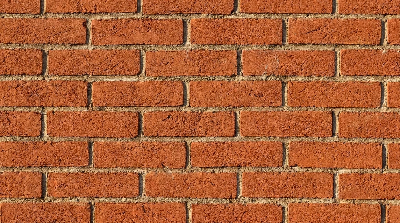 Brick masonry wall showing evenly bonded bricks with visible mortar joints and running bond pattern.
