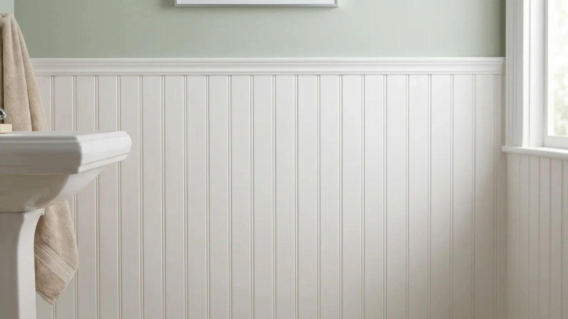 Bathroom wall with vertical beadboard panels and narrow rounded grooves below a smooth upper wall.