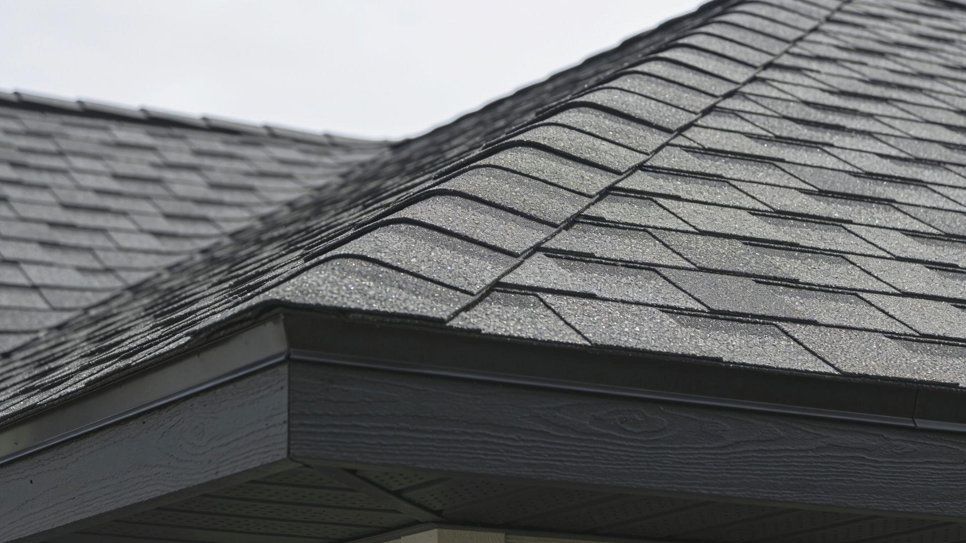 Asphalt starter shingles line the roof eaves while overlapping ridge cap shingles protect the peak FileName-starter-shingles-and-ridge-caps