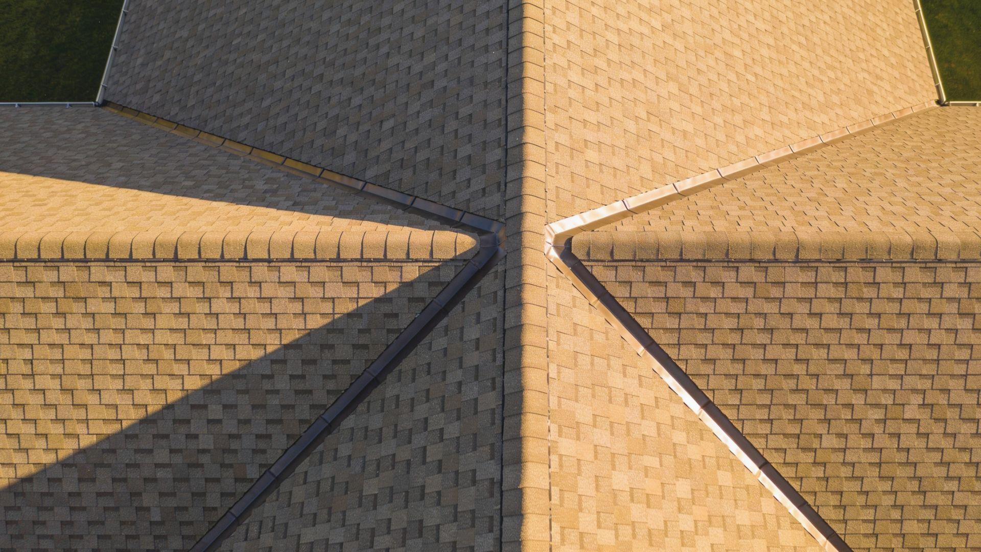 Pitched residential roof showing intersecting ridges, sloping hips, and a metal-lined roof valleyFileName-roof-ridges-hips-and-valleys