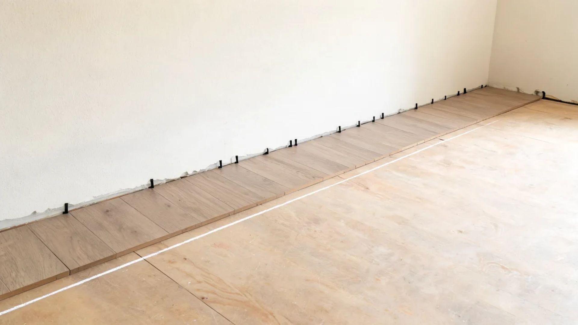 First vinyl plank row aligned with a chalk line and spaced away from the wall.File name: first-row-vinyl-plank-layout