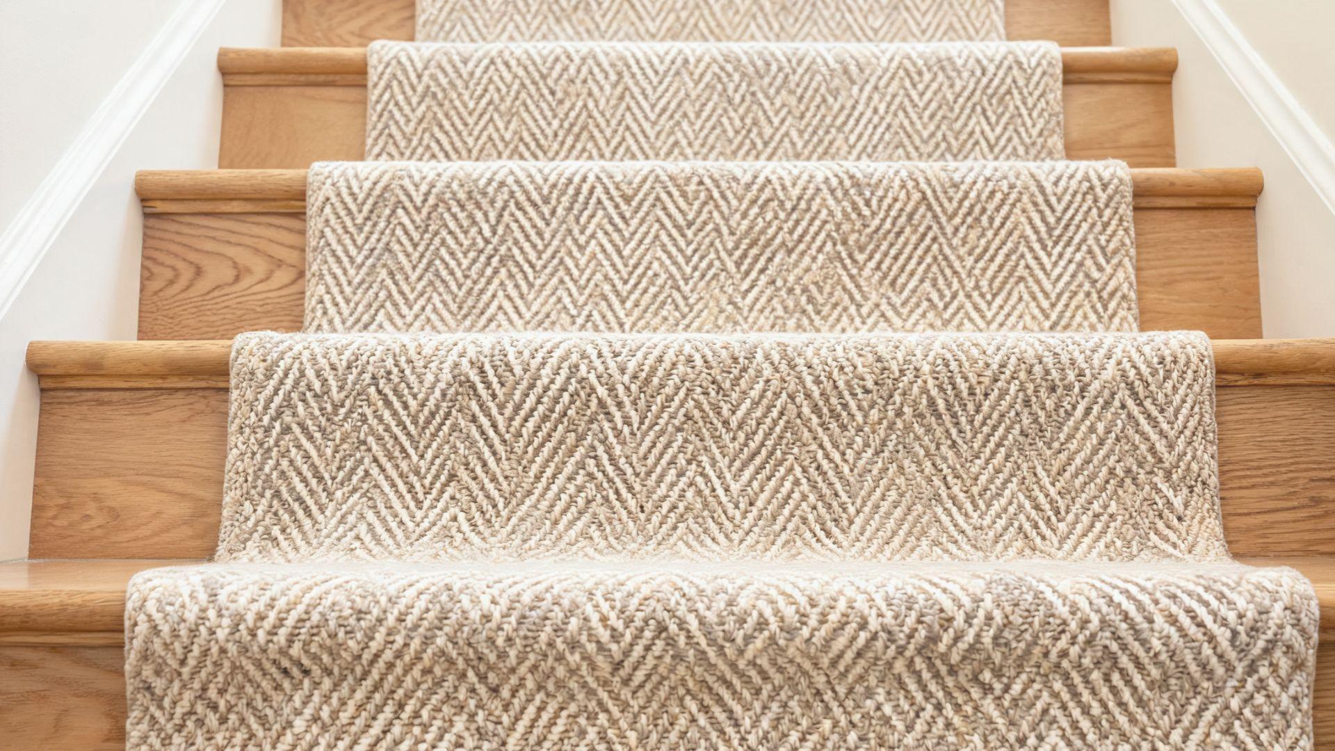 Neutral herringbone stair runner fitted over wooden staircase treads