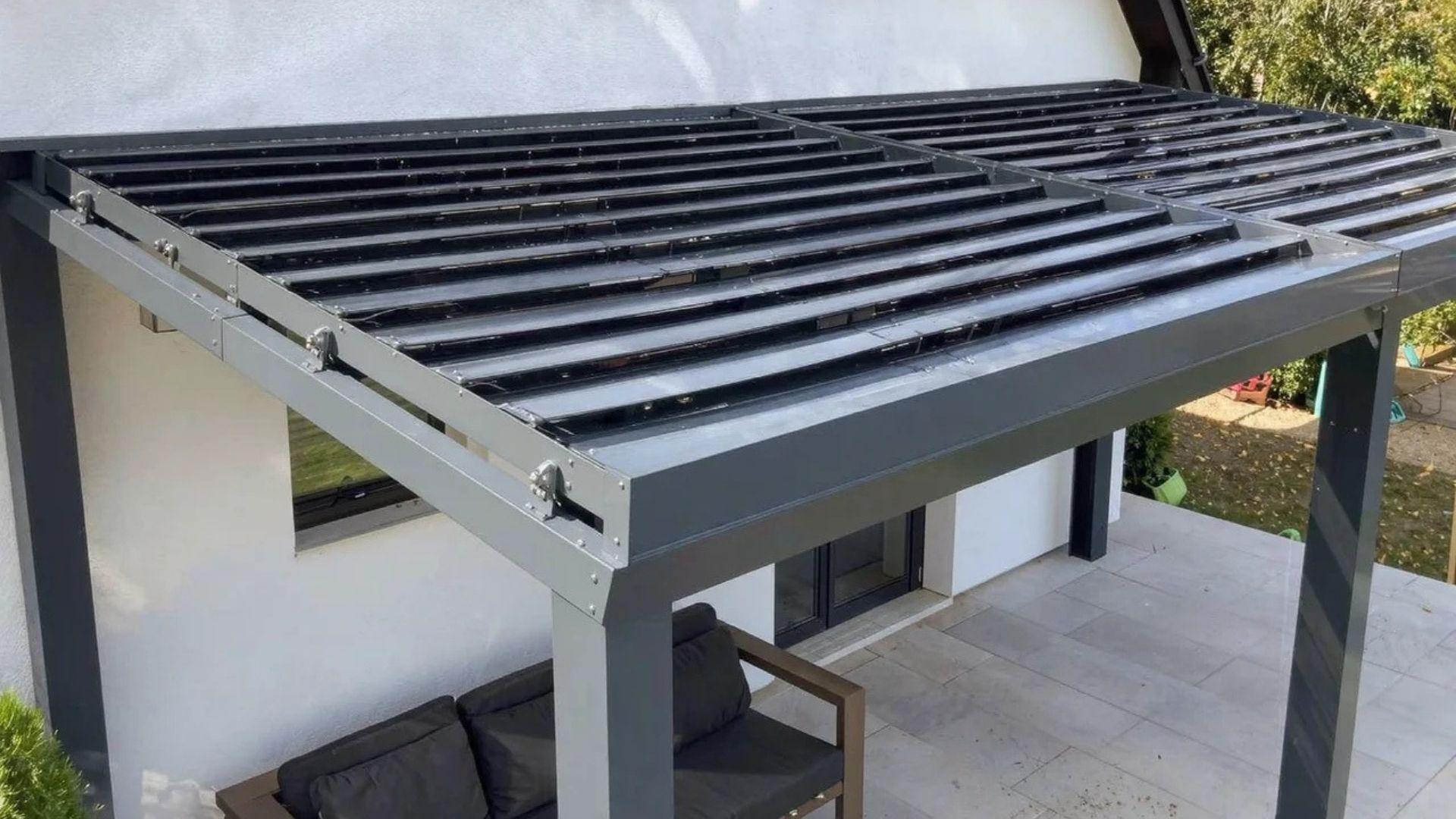 Residential patio with a motorized louvered pergola, adjustable roof blades, metal frame, and four support posts.