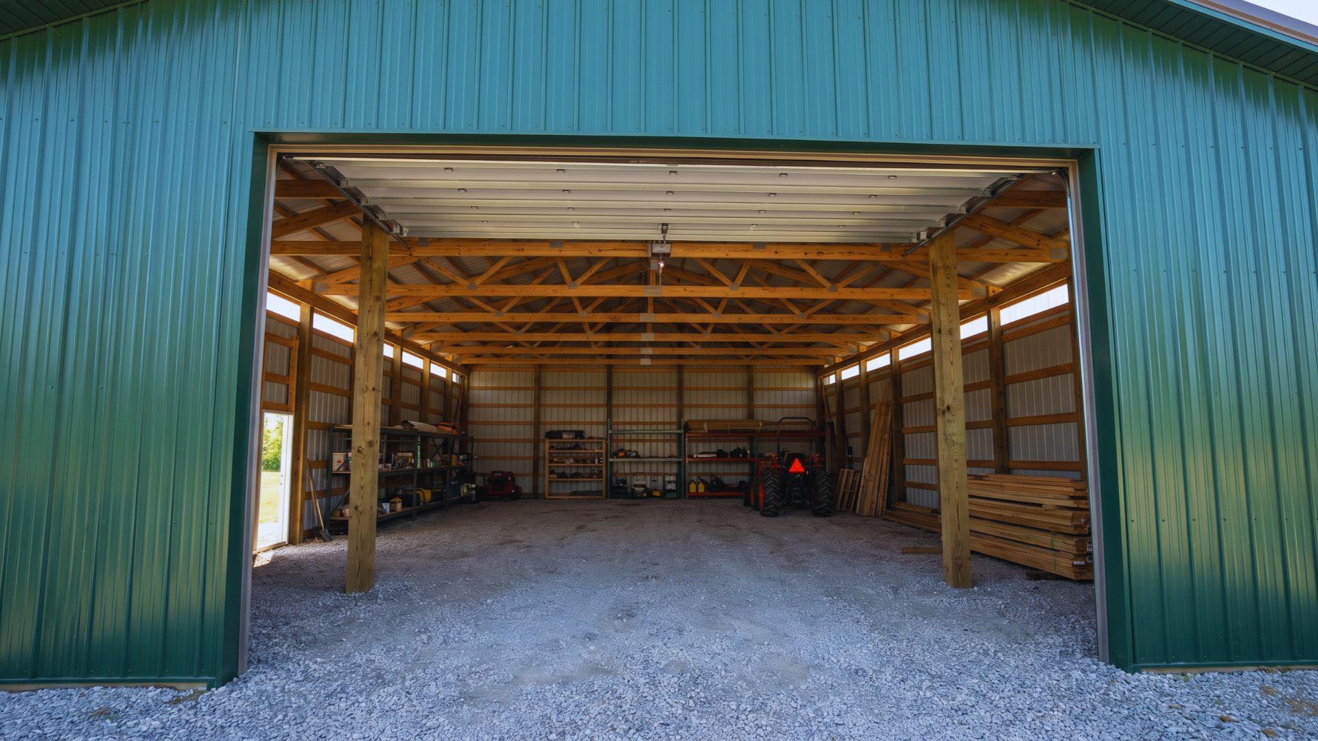 Post frame workshop with steel siding, a wide entrance, spaced columns, and an open interior.