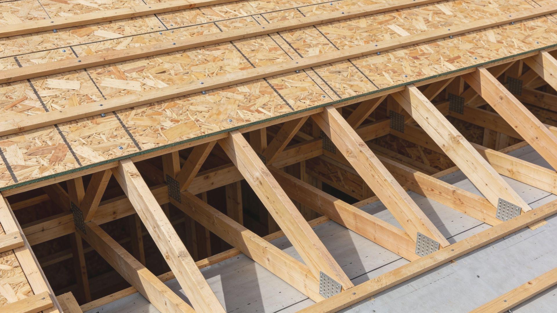 Plywood roof decking panels fastened across exposed wooden rafters on a residential roof