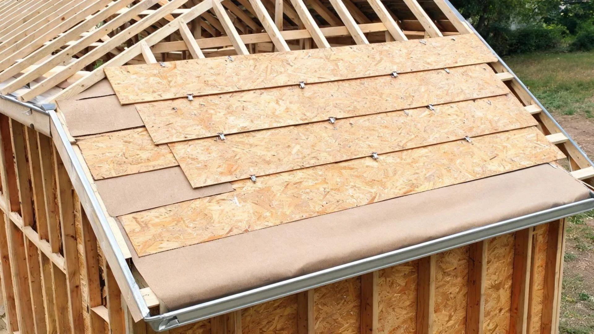 Shed roof with OSB sheathing panels, staggered joints, panel clips, underlayment, and eave drip edge.