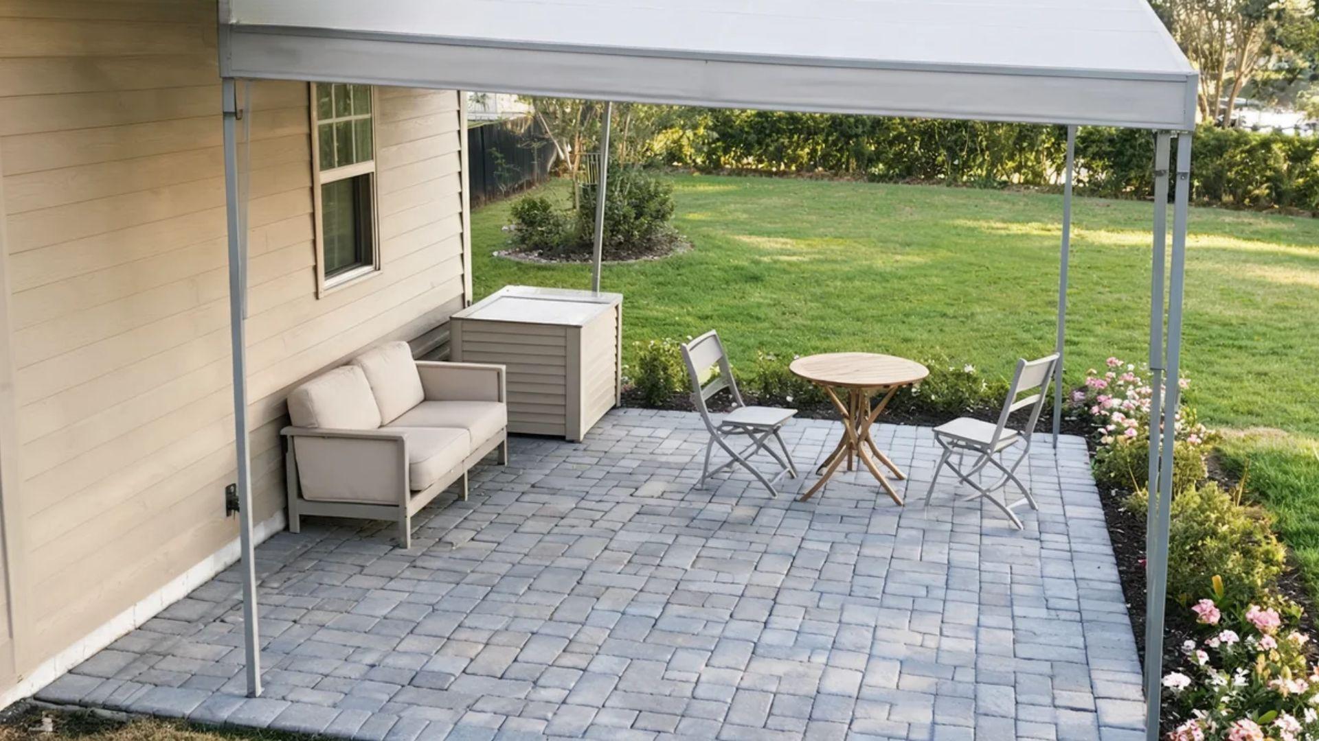 Small covered patio with a loveseat, bistro table, chairs, and storage bench.