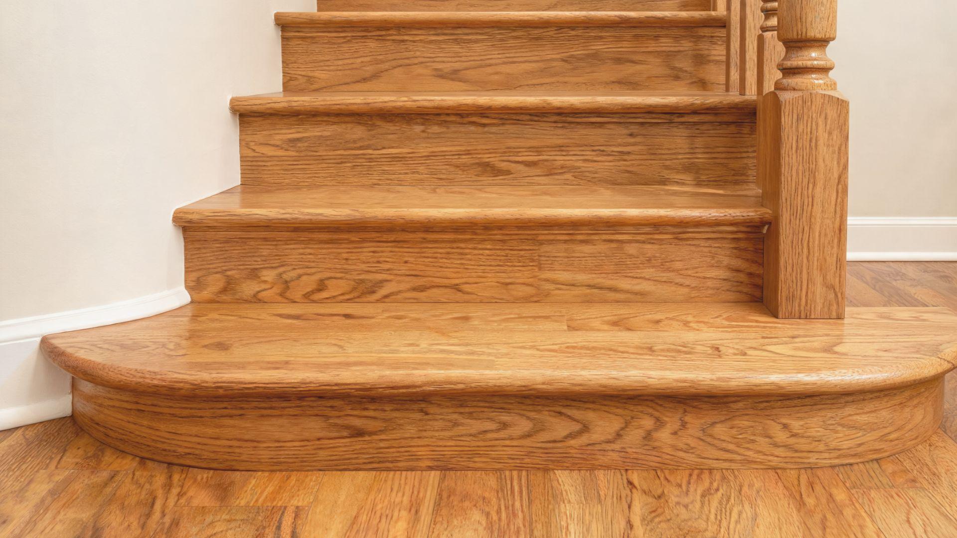 Rounded wooden bullnose step extending beyond the staircase at the bottom