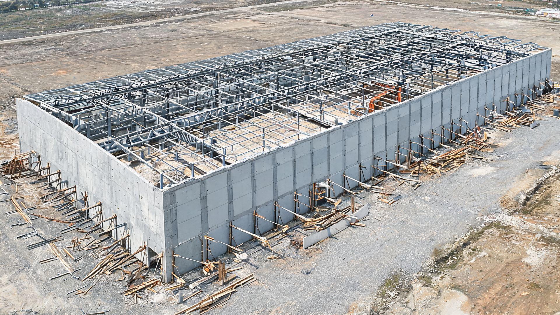 Large single-story commercial building under construction with concrete tilt-up wall panels.