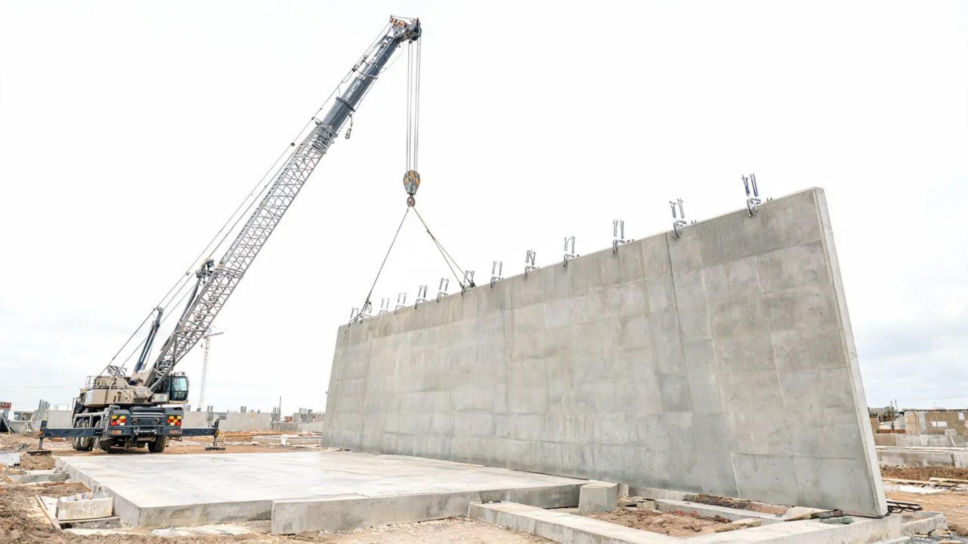 Crane lifting a cured tilt-up concrete panel from horizontal to vertical.