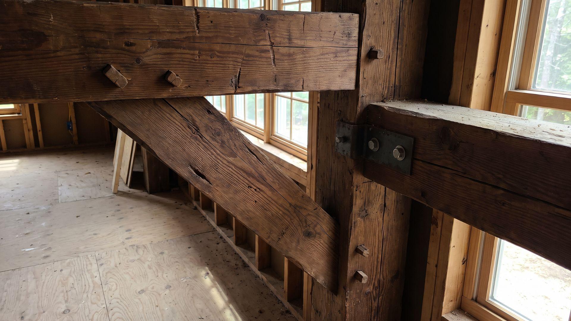 Heavy timber frame with wood joints, wooden pegs, and metal connectors visible at connection points.