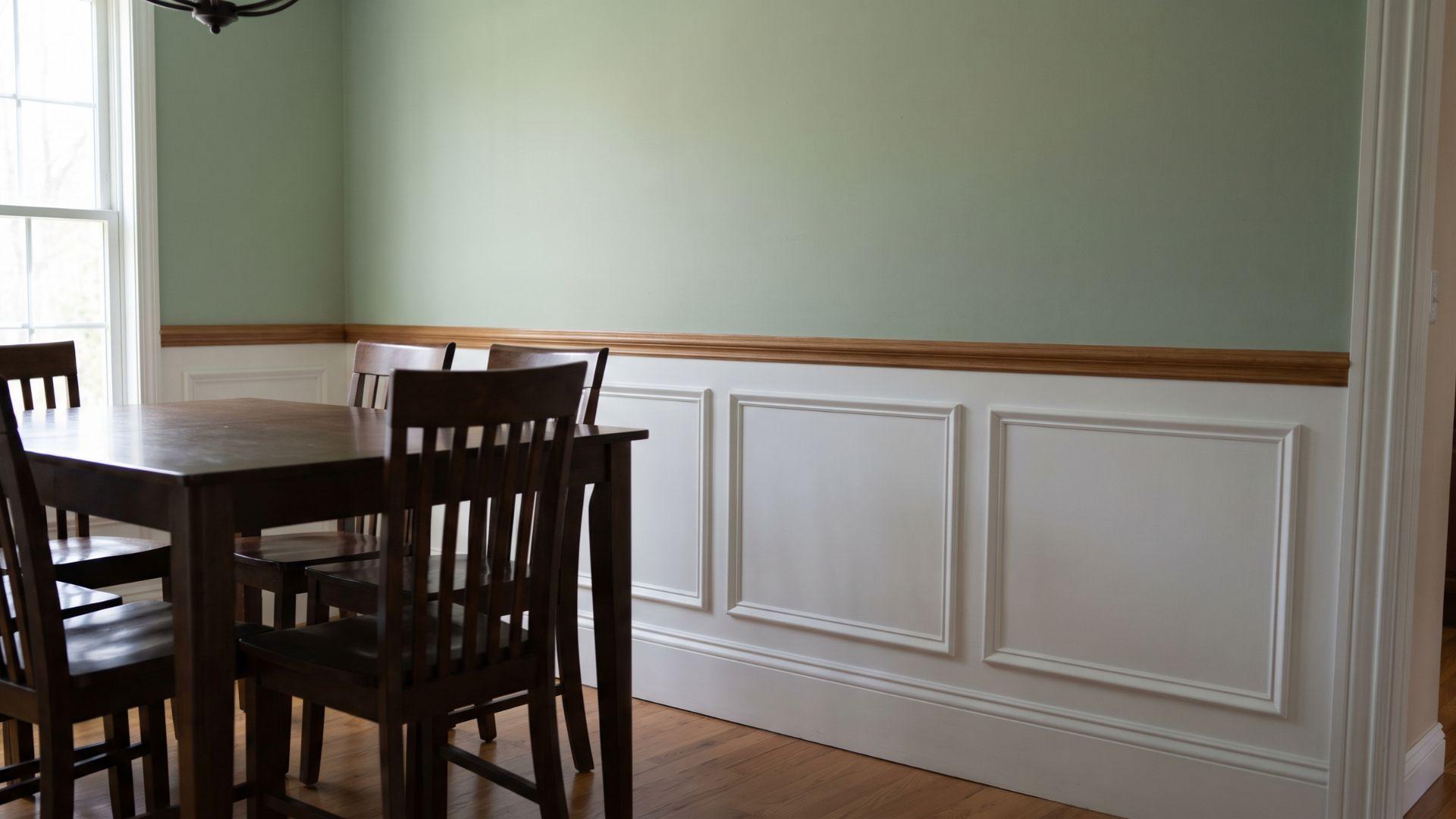 Dining room wall with half-height rectangular wainscoting, a chair rail, and a baseboard.