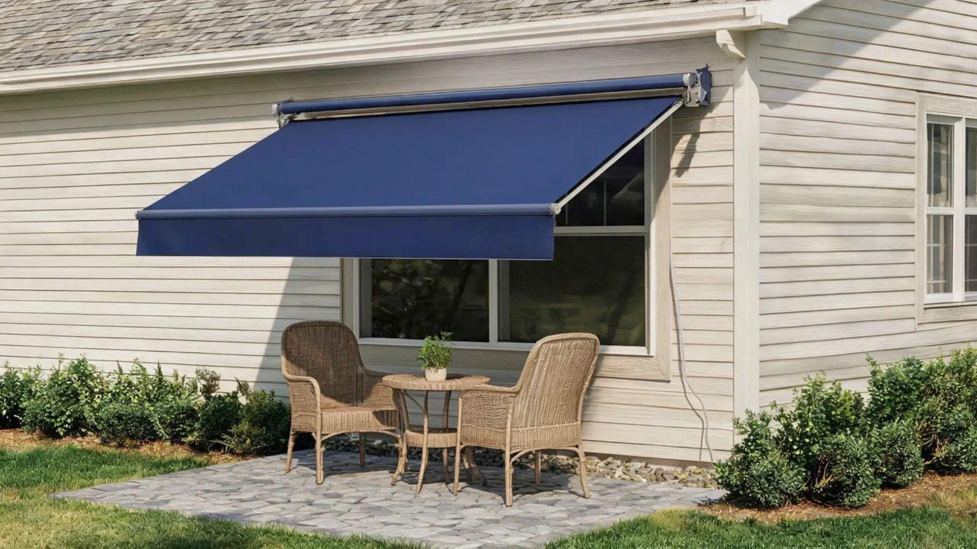 Retractable awning attached to a house above a paved patio with chairs.